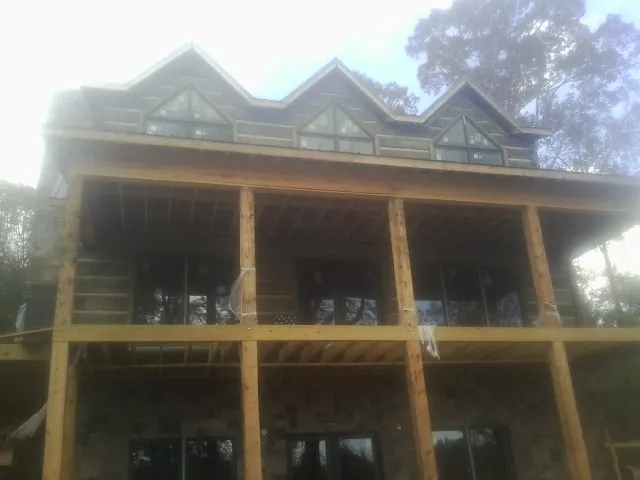 Dormers and porch framing on a large log home under construction — Roof Coating work by our crew in Cub Run