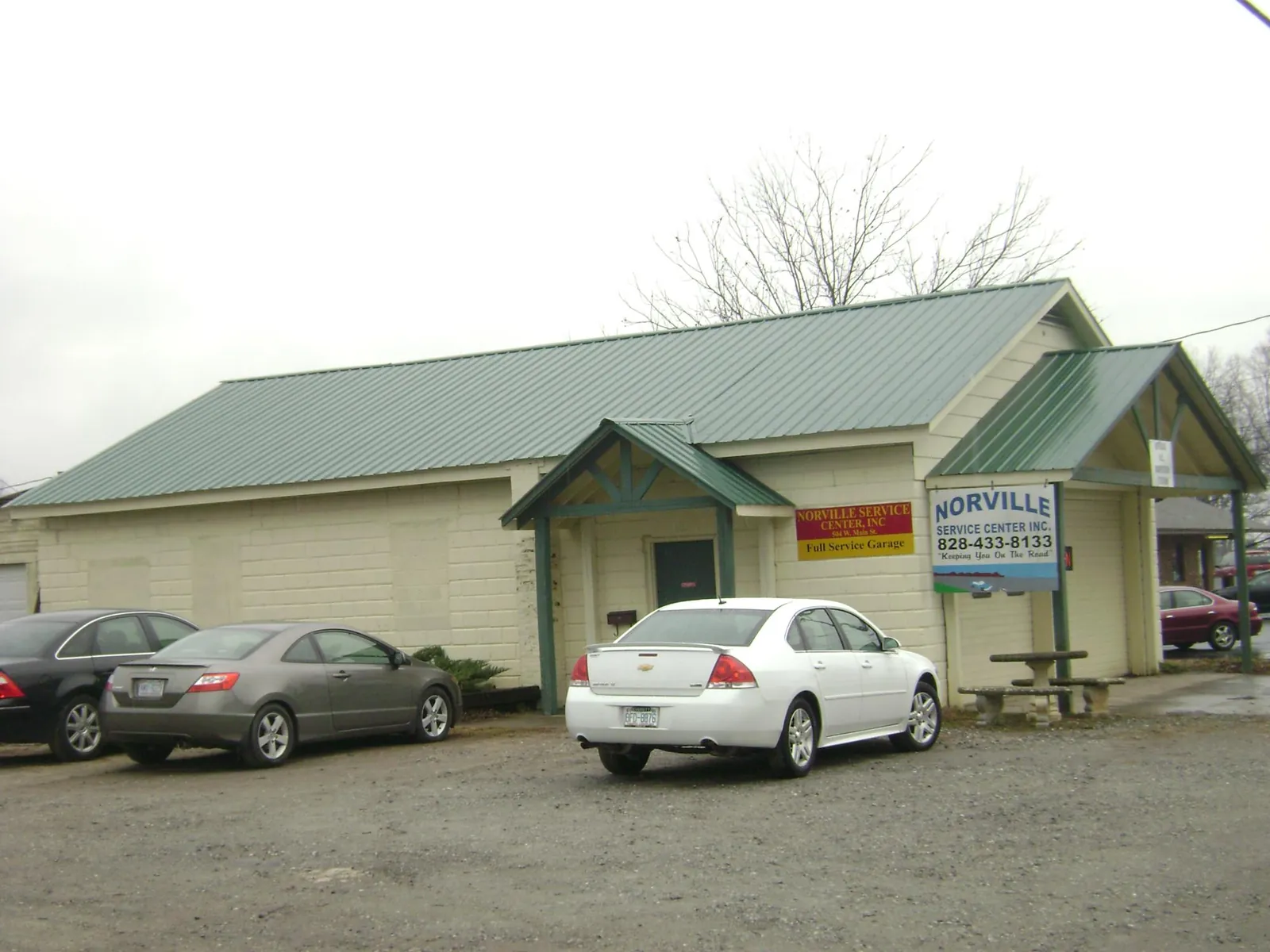 Green metal roof on a service garage with a covered entry in Cub Run