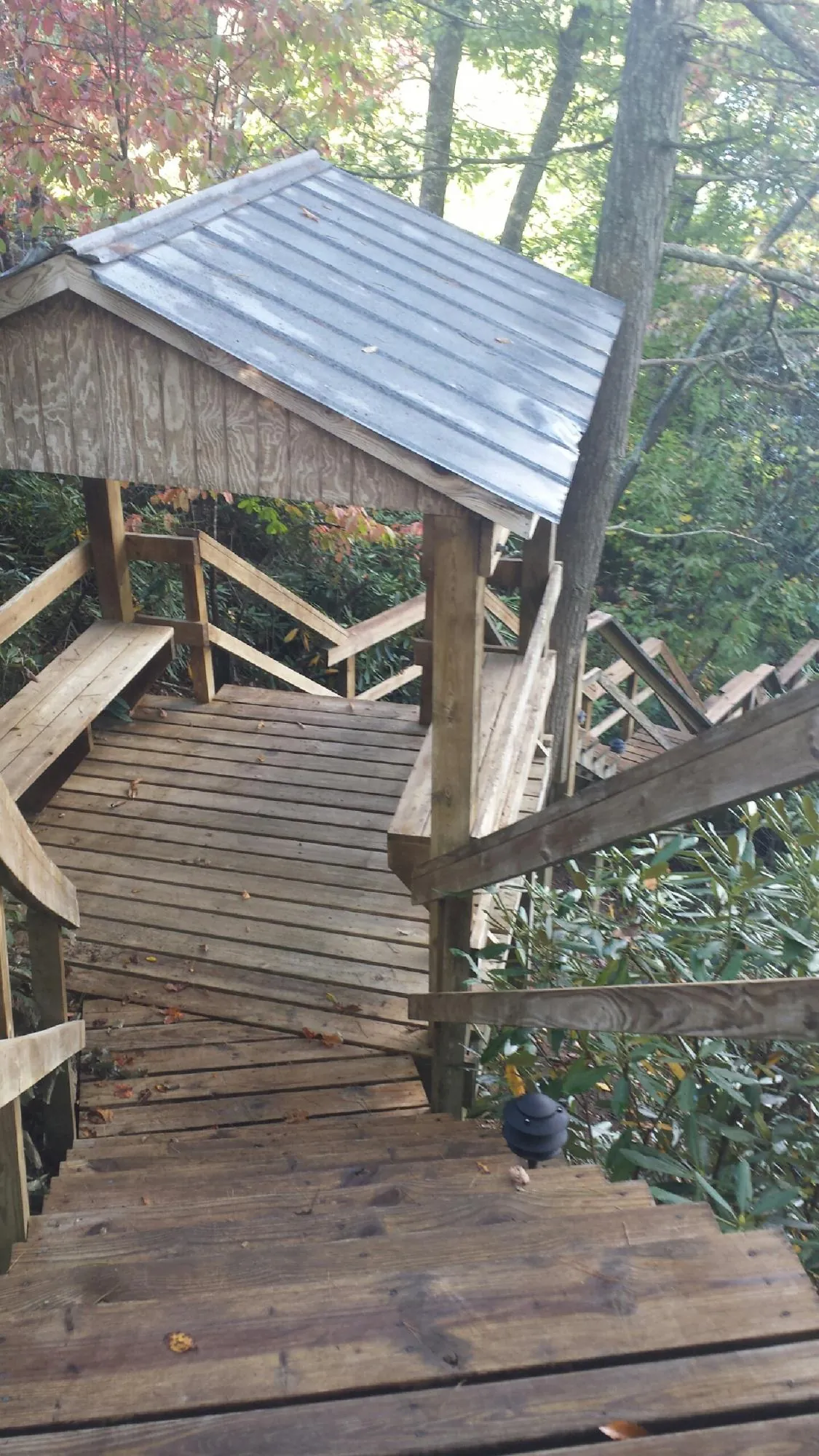 Metal roofed shelter over wooden steps on a wooded walkway — Skylight Repair & Installation work by our crew in Cub Run