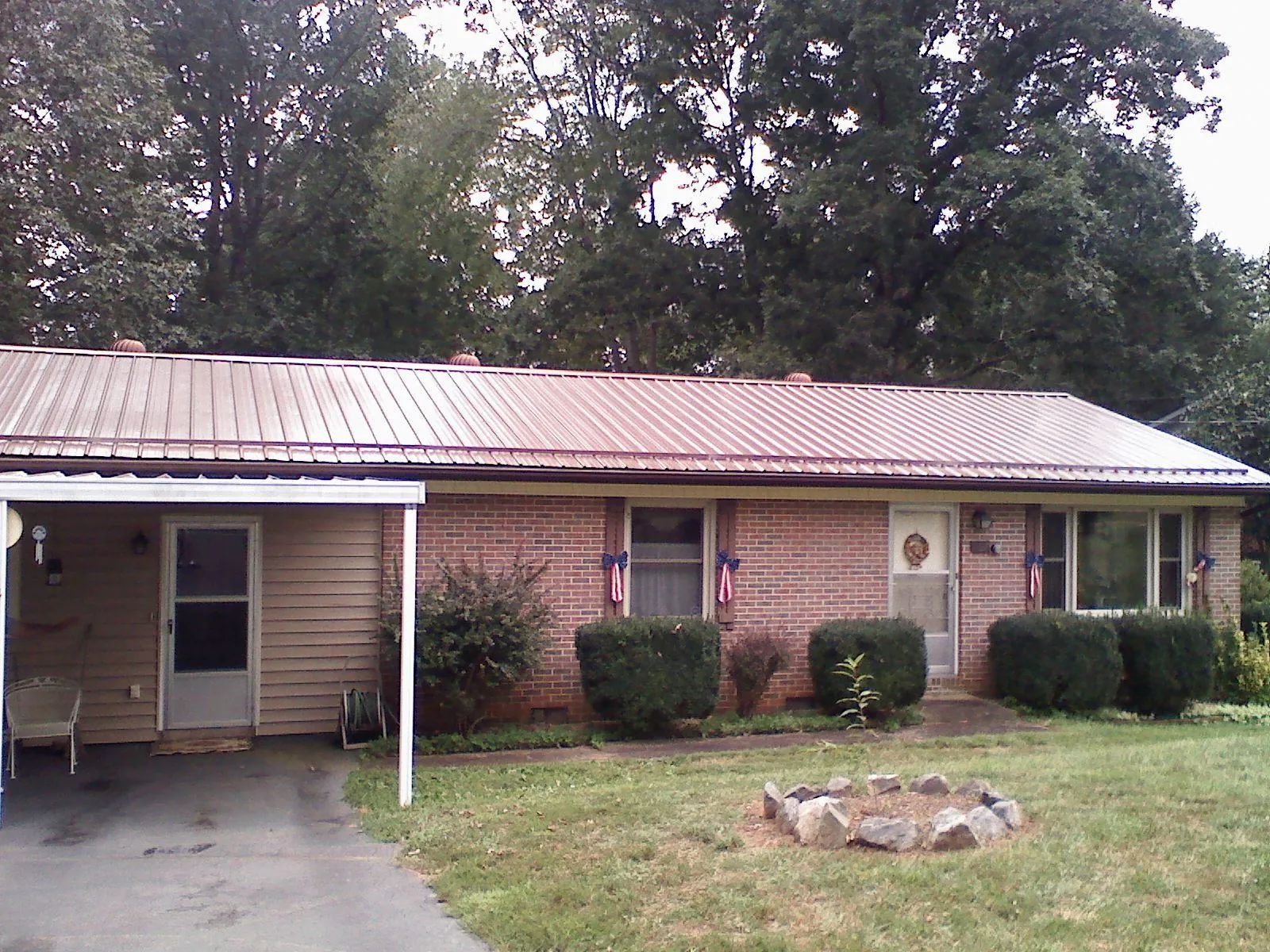 Bronze metal roof and carport on a brick ranch home — Roof Repair work by our crew in Cub Run
